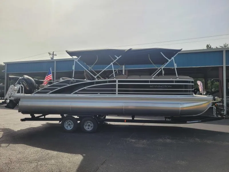 Slide: The Image of 2024 Bennington 25 RSB pontoon boat on trailer, featuring sleek design and dual bimini tops. - 2