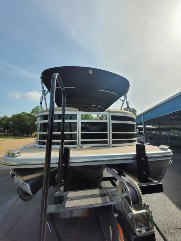 Slide: The Image of 2024 Bennington 25 RSB pontoon boat on trailer, under a clear sky. - 4