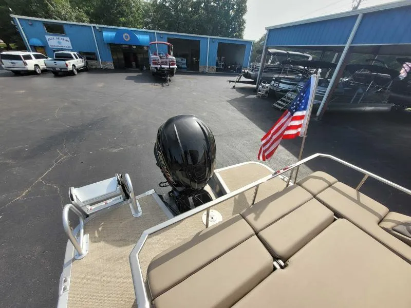 Slide: The Image of 2024 Bennington 25 RSB pontoon boat with American flag at dealership. - 8