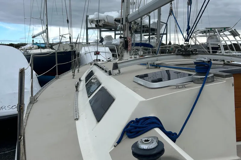 Slide: The Image of 1983 O'Day 39 sailboat deck with rigging and hatches, docked among other boats. - 14