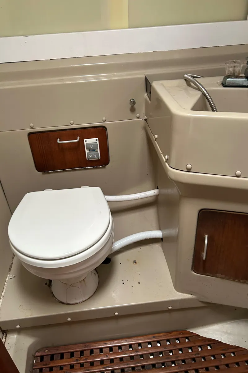 Slide: The Image of 1983 O'Day 39 yacht bathroom with toilet and sink, featuring wood accents. - 19