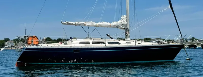 Slide: The Image of 1983 O'Day 39 sailboat on calm water, featuring sleek design and white sails. - 2