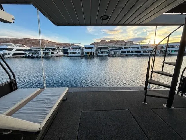 Slide: The Image of 1999 Horizon Stoke Houseboat with scenic lake view and spiral staircase at sunset. - 11