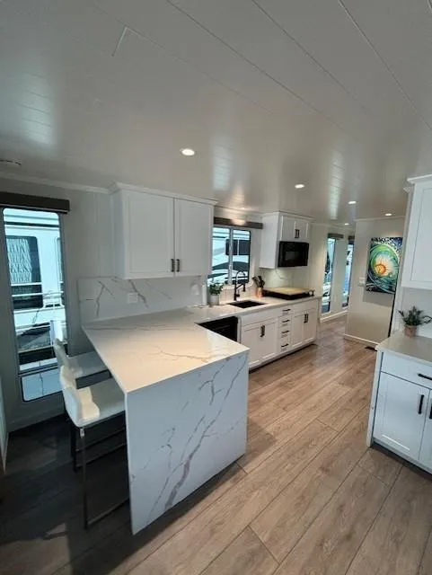 Slide: The Image of Modern kitchen interior in 1999 Horizon Stoke House, featuring sleek white cabinetry and wood flooring. - 14