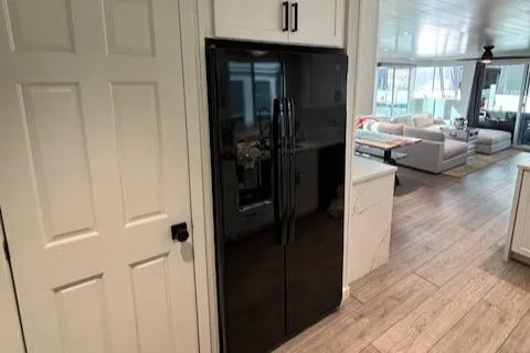 Slide: The Image of Modern kitchen interior in 1999 Horizon Stoke House, featuring black refrigerator and wooden flooring. - 17