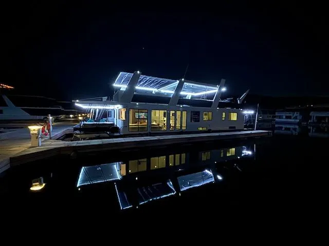 Slide: The Image of Illuminated 1999 Horizon Stoke Houseboat at night, reflecting on calm water. - 2
