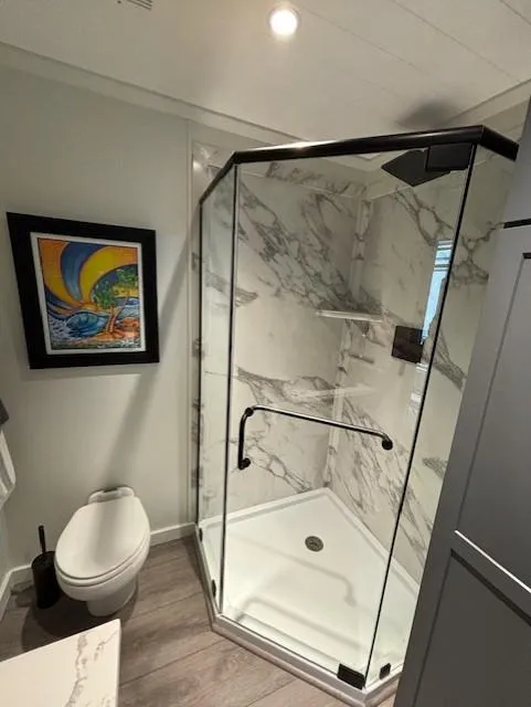 Slide: The Image of Modern bathroom with glass shower, marble walls, and colorful artwork. Horizon Stoke House 1999 model. - 21