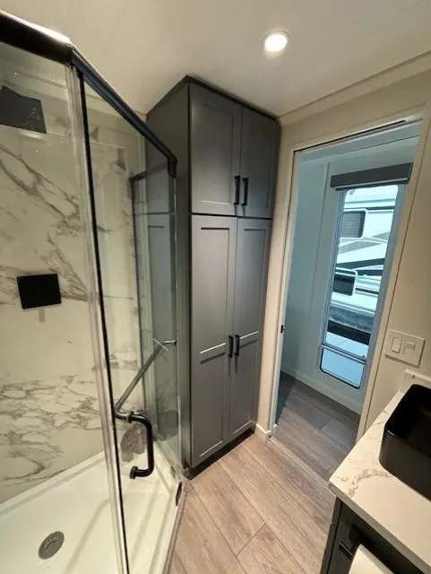 Slide: The Image of Modern bathroom in 1999 Horizon Stoke House RV with glass shower and sleek cabinetry. - 22