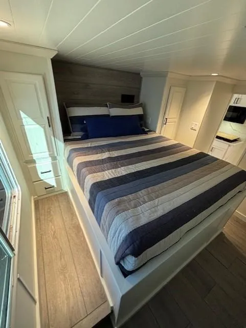 Slide: The Image of Cozy bedroom in 1999 Horizon Stoke House, featuring a striped bedspread and modern decor. - 23