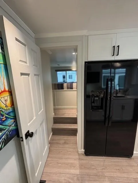 Slide: The Image of Modern kitchen interior in 1999 Horizon Stoke House, featuring black refrigerator and wooden flooring. - 24