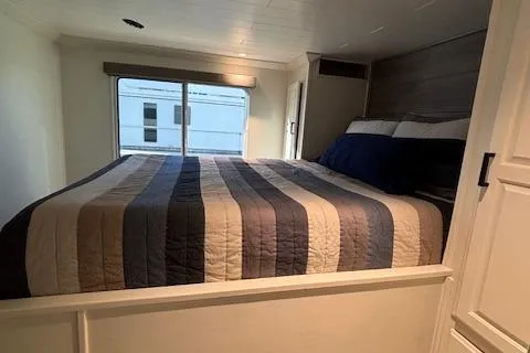 Slide: The Image of Cozy bedroom in 1999 Horizon Stoke House with striped bedding and large window. - 26