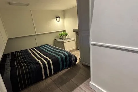 Slide: The Image of Cozy bedroom in 1999 Horizon Stoke House with striped bedding and modern decor. - 27