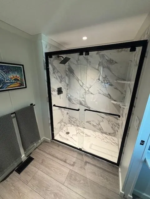 Slide: The Image of Modern bathroom with glass shower, marble walls, and wood flooring in 1999 Horizon Stoke House. - 35