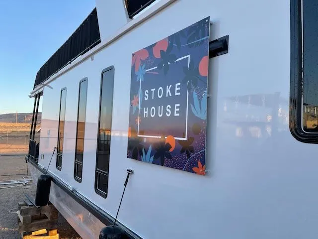 Slide: The Image of 1999 Horizon Stoke House boat with floral sign, docked outdoors. - 4