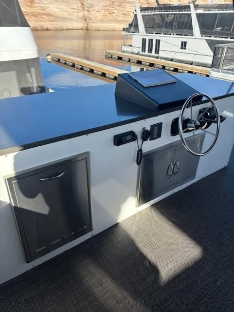 Slide: The Image of 1999 Horizon Stoke House boat helm with steering wheel and control panel, docked by the water. - 45