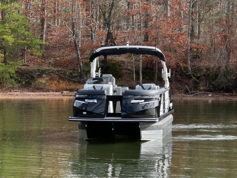 Slide: The Image of 2025 Montara Surf Boss 2.0 25 pontoon boat on a calm lake. - 1