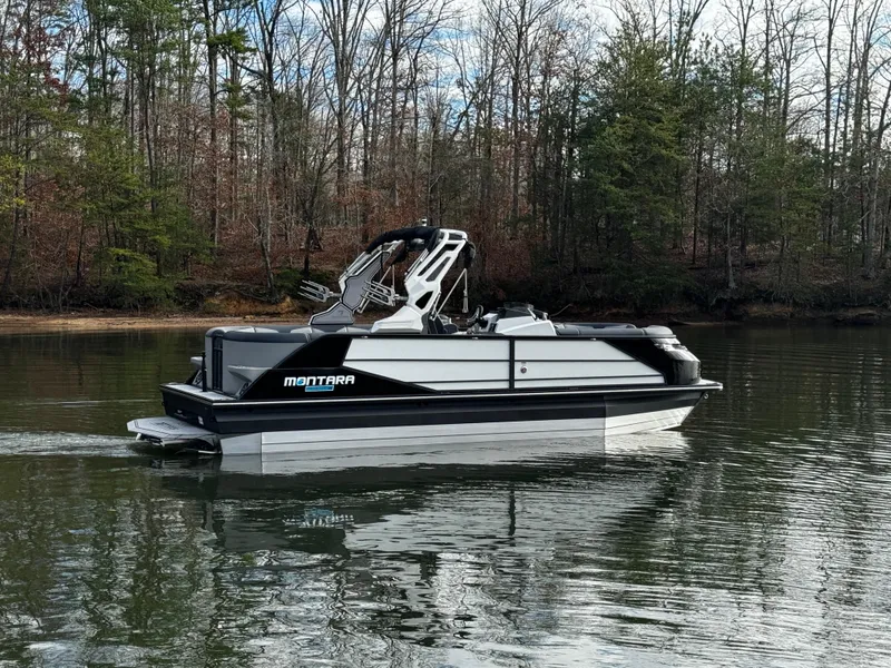 Slide: The Image of 2025 Montara Surf Boss 2.0 25 boat on a calm lake with forest backdrop. - 10