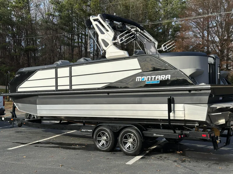 Slide: The Image of 2025 Montara Surf Boss 2.0 25 boat on trailer in parking lot. - 13