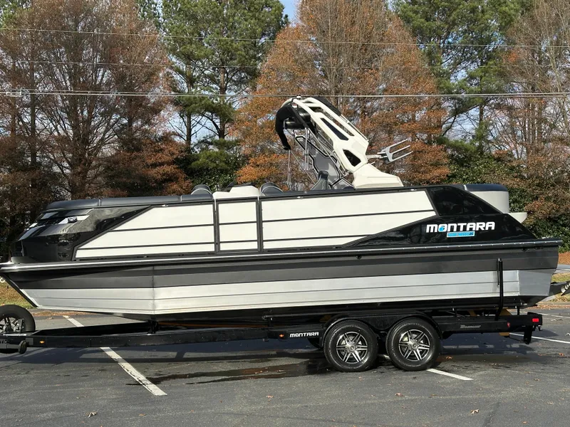 Slide: The Image of 2025 Montara Surf Boss 2.0 25 boat on trailer, parked outdoors. - 14