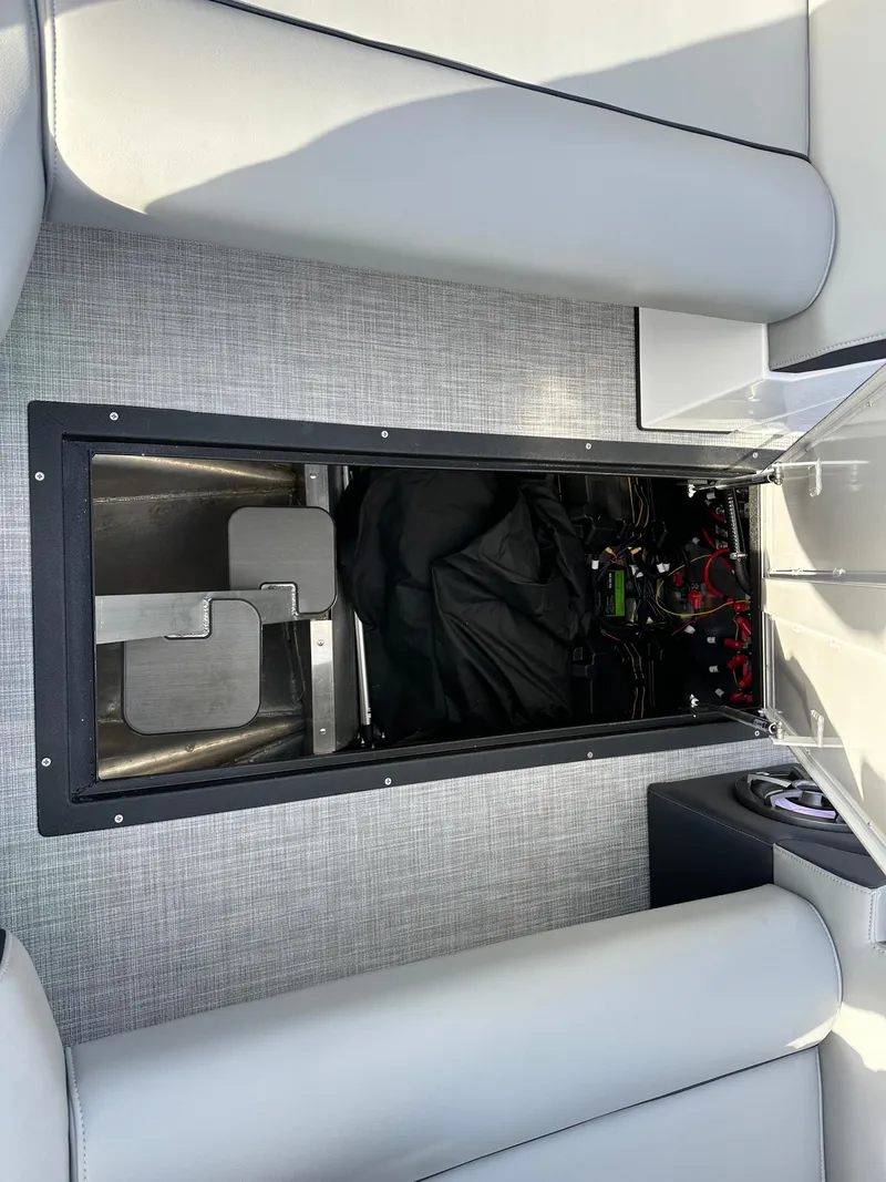 Slide: The Image of 2025 Montara Surf Boss 2.0 25 interior storage compartment with visible wiring and equipment. - 24