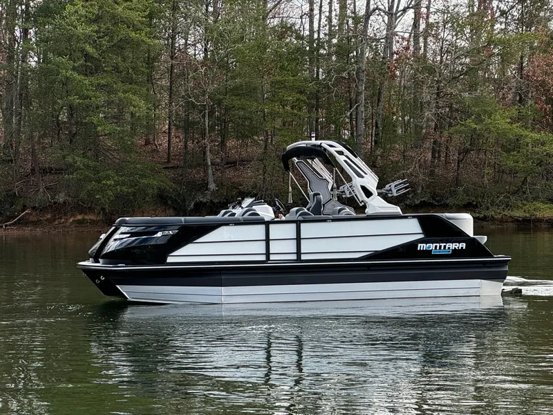 Slide: The Image of 2025 Montara Surf Boss 2.0 25 boat on a calm lake with forested background. - 4