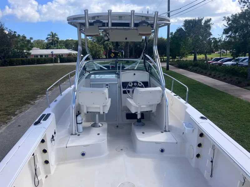 Slide: The Image of 1998 Pro-Line 241 Walkaround boat with dual seats and steering console, parked outdoors. - 10