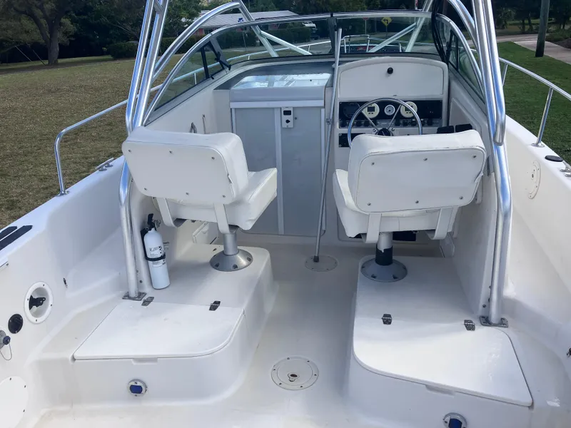 Slide: The Image of 1998 Pro-Line 241 Walkaround boat interior with dual white seats and steering console. - 12