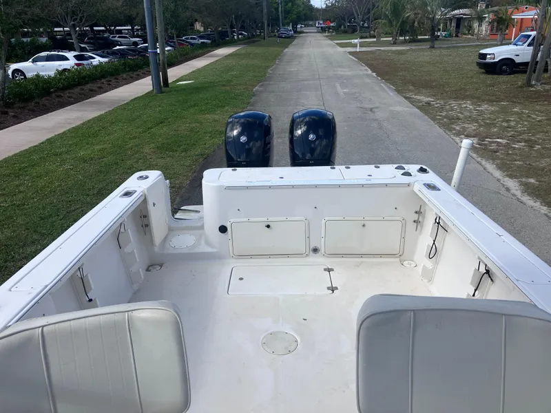 Slide: The Image of 1998 Pro-Line 241 Walkaround boat with dual outboard motors on a paved road. - 15