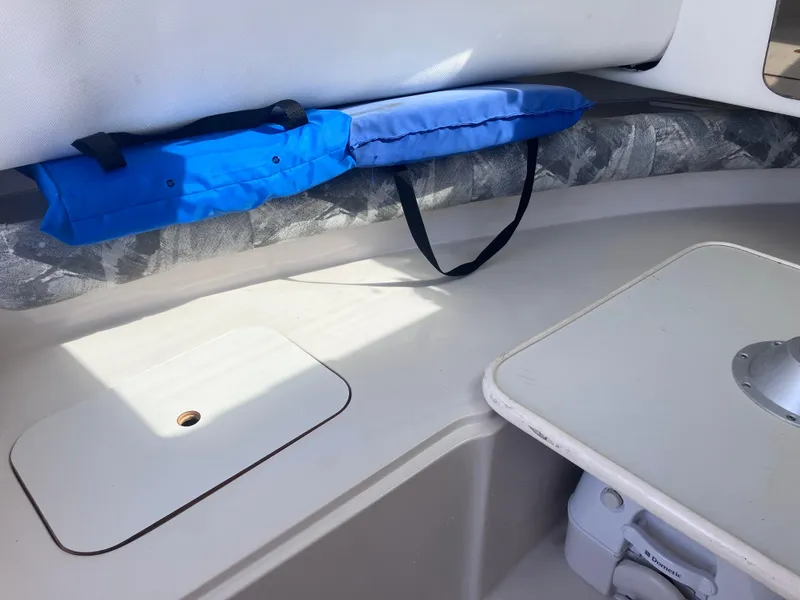 Slide: The Image of Interior of 1998 Pro-Line 241 Walkaround boat with blue cushion and storage area. - 20