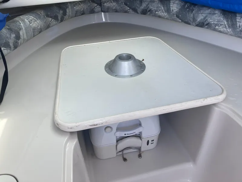 Slide: The Image of 1998 Pro-Line 241 Walkaround cabin interior with table and portable toilet. - 22