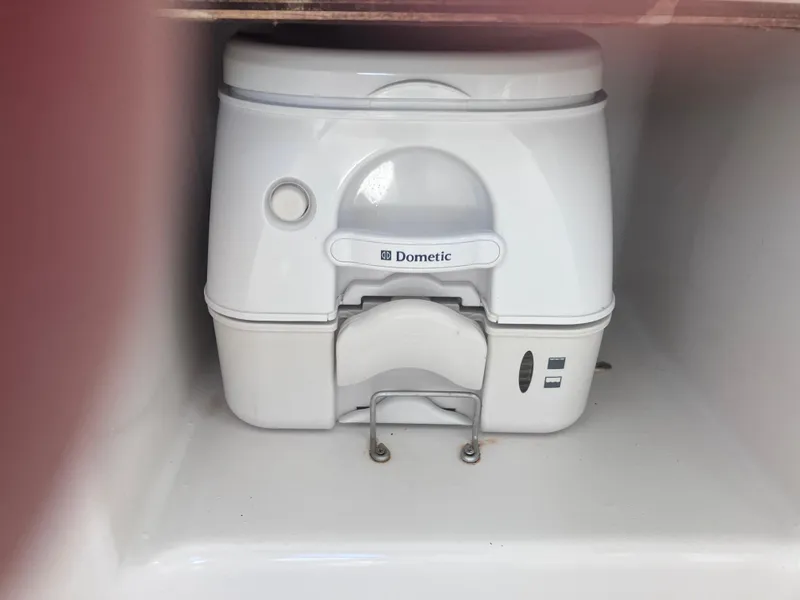Slide: The Image of Dometic portable toilet in 1998 Pro-Line 241 Walkaround boat storage compartment. - 23