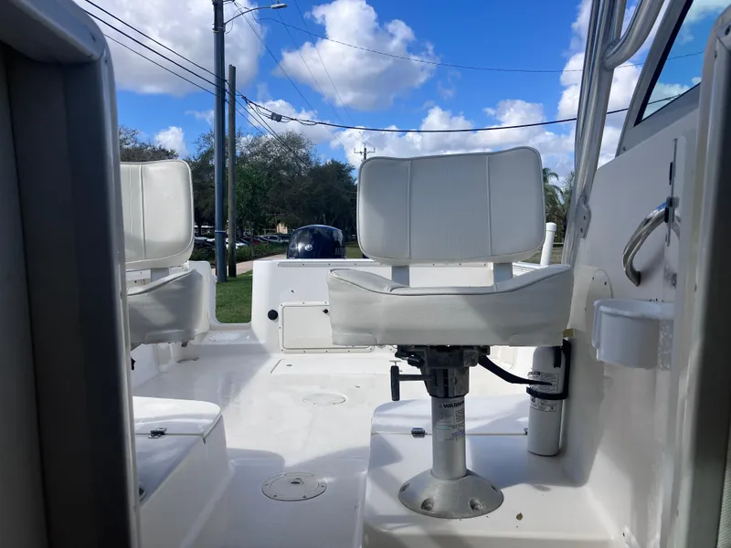 Slide: The Image of 1998 Pro-Line 241 Walkaround boat interior with white seating and clear sky background. - 24