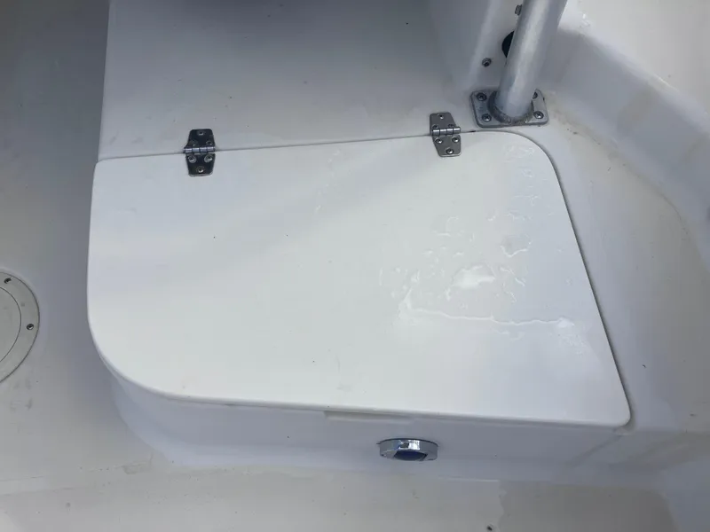 Slide: The Image of 1998 Pro-Line 241 Walkaround boat deck with storage compartment and metal hinges. - 29