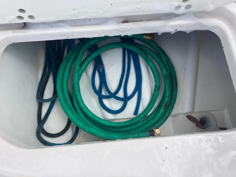Slide: The Image of Storage compartment with hoses on a 1998 Pro-Line 241 Walkaround boat. - 30