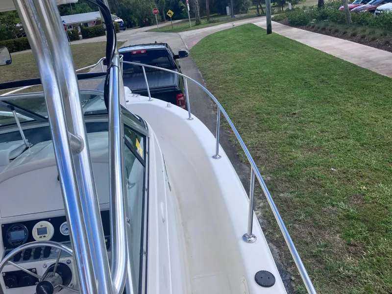 Slide: The Image of 1998 Pro-Line 241 Walkaround boat on trailer, parked near grassy area. - 33