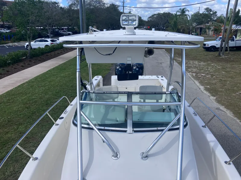 Slide: The Image of 1998 Pro-Line 241 Walkaround boat with T-top and windshield, parked on a road. - 38