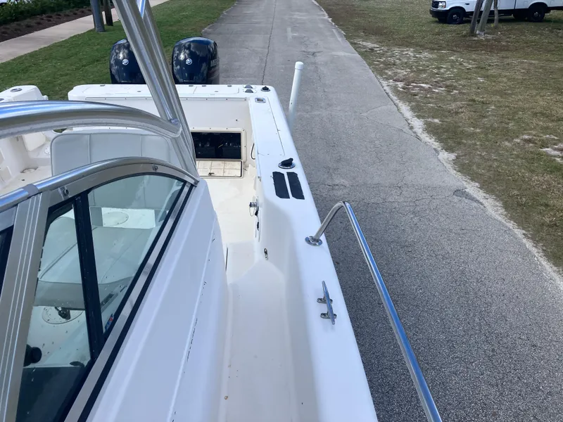 Slide: The Image of 1998 Pro-Line 241 Walkaround boat, view of deck and dual engines, parked on pavement. - 42