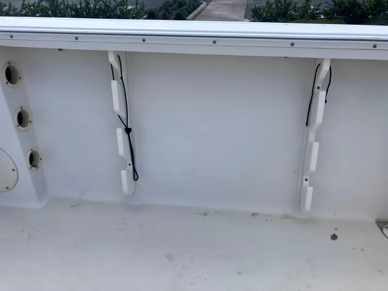 Slide: The Image of 1998 Pro-Line 241 Walkaround boat interior with rod holders and clean white deck. - 43