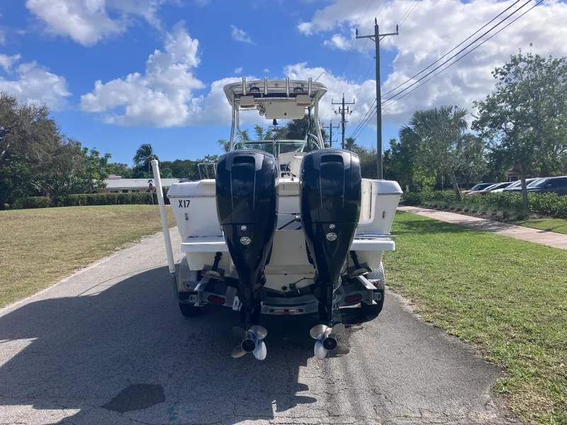 Slide: The Image of 1998 Pro-Line 241 Walkaround boat with dual outboard motors on a sunny day. - 6
