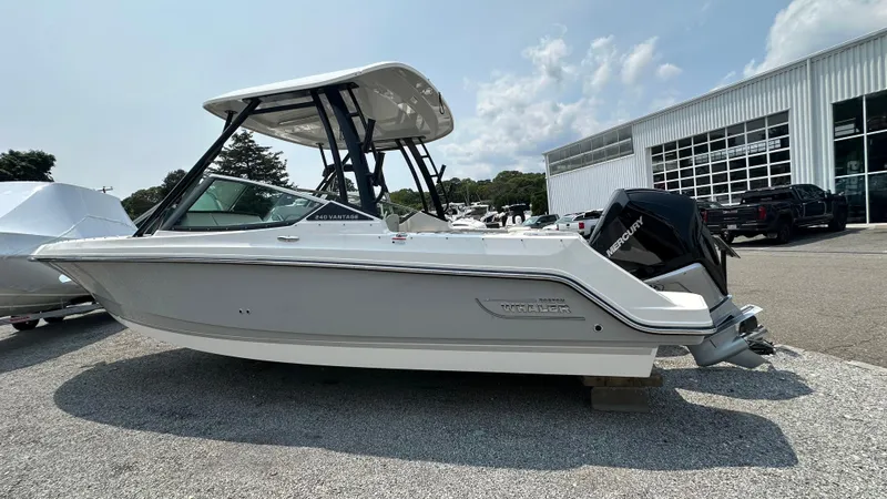 The Image of 2025 Boston Whaler 240 Vantage boat displayed outdoors near a modern building. - 0