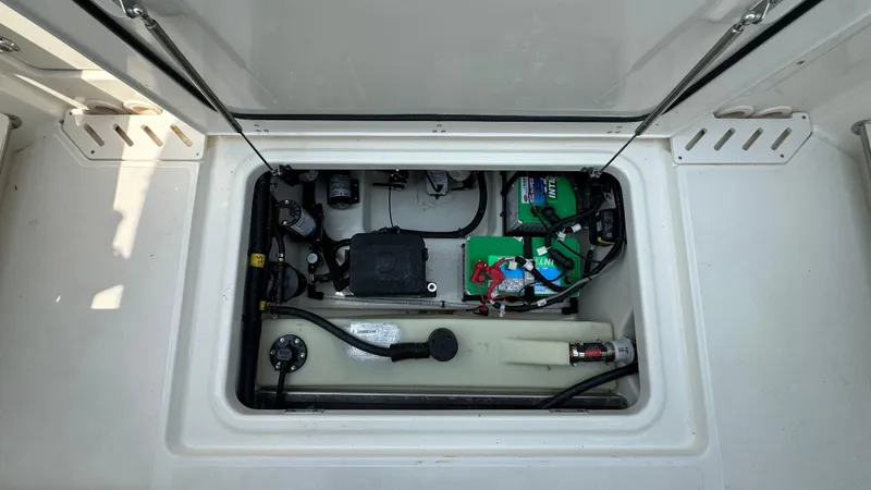 Slide: The Image of 2025 Boston Whaler 240 Vantage storage compartment with battery and wiring. - 10