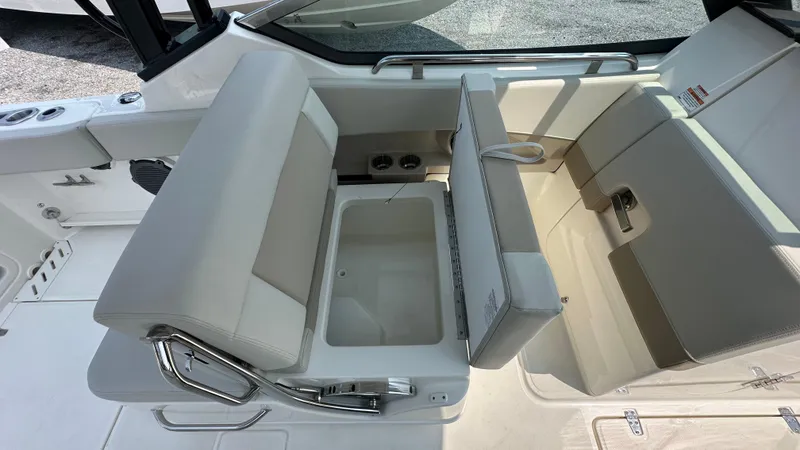Slide: The Image of 2025 Boston Whaler 240 Vantage boat interior with beige seating and storage compartment. - 18