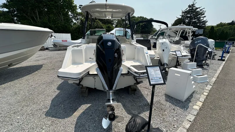 Slide: The Image of 2025 Boston Whaler 240 Vantage boat displayed outdoors, rear view with outboard motor. - 2