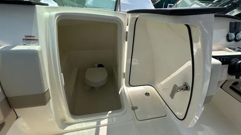 Slide: The Image of 2025 Boston Whaler 240 Vantage boat interior with open compartment showing a toilet. - 20
