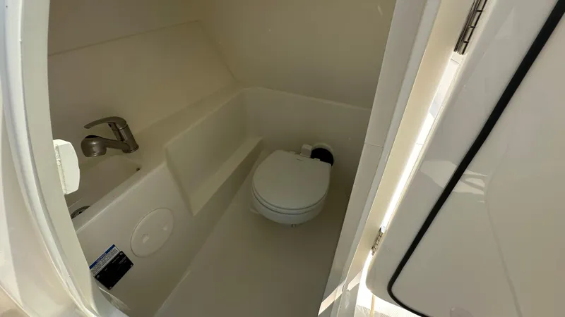 Slide: The Image of 2025 Boston Whaler 240 Vantage boat interior with compact bathroom and toilet. - 21