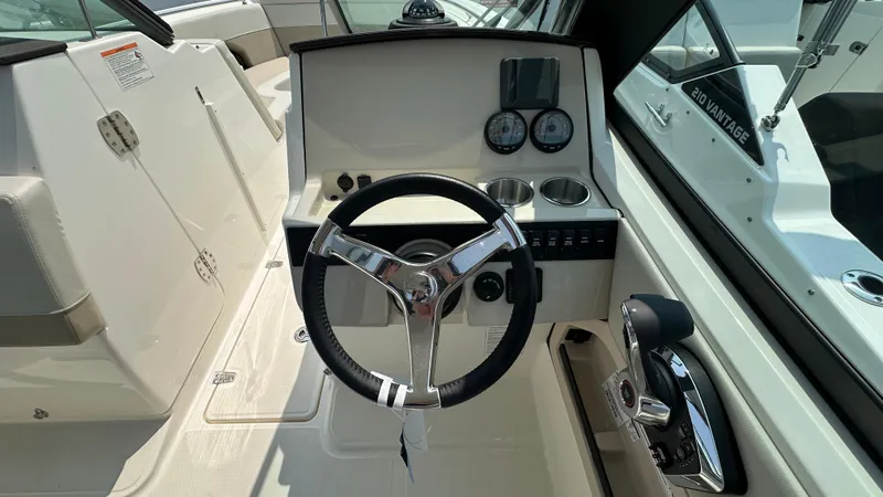 Slide: The Image of 2025 Boston Whaler 240 Vantage helm with steering wheel and control panel. - 25