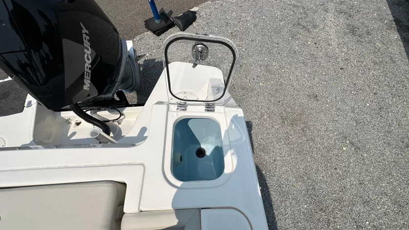 Slide: The Image of 2025 Boston Whaler 240 Vantage boat with Mercury engine and open storage compartment. - 6