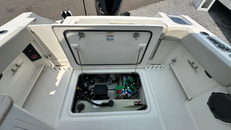 Slide: The Image of 2025 Boston Whaler 240 Vantage boat storage compartment with open hatch, showcasing internal components. - 9