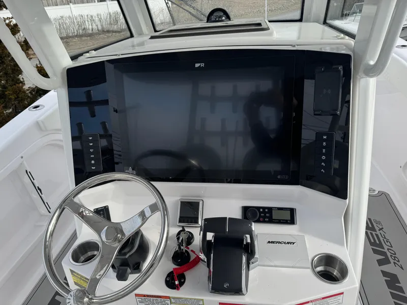 Slide: The Image of 2025 Twin Vee 280 GFX2 CC boat dashboard with steering wheel and control panel. - 4