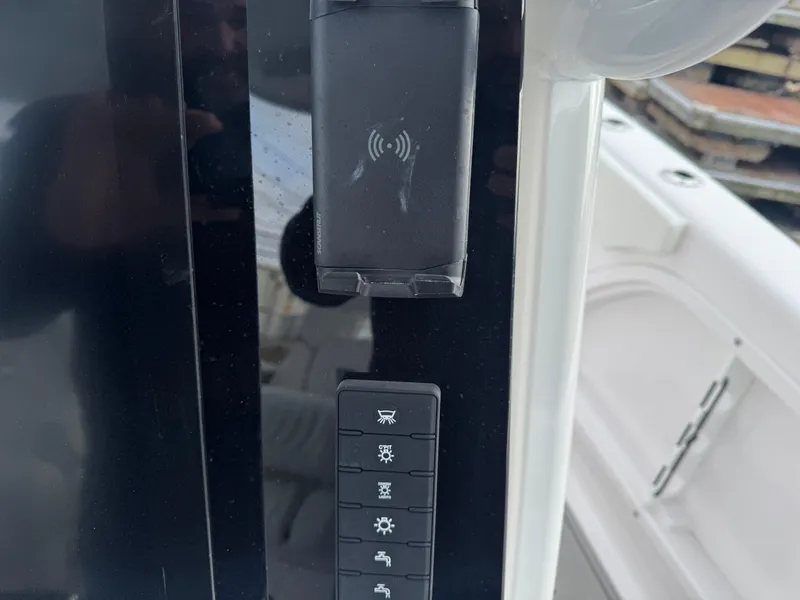 Slide: The Image of Control panel of 2025 Twin Vee 280 GFX2 CC boat with wireless charging pad. - 7